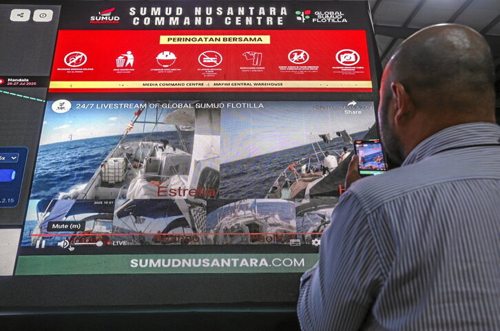 Un periodista sigue a la Flotilla desde un monitor de vídeo.