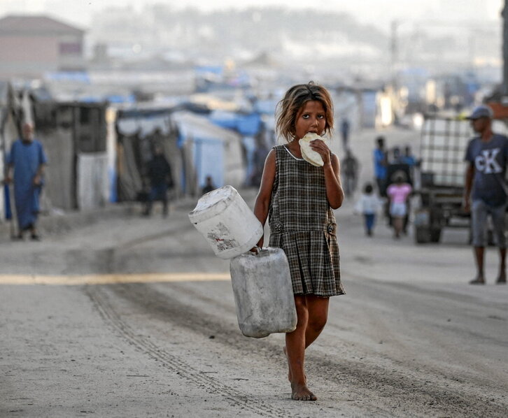 Una niña camina entre tiendas de desplazados en Deir al-Balah.