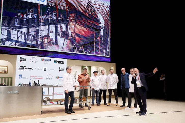 Benjamín Lana, director del congreso, toma el micrófono rodeado de cocineros y del director de Albaola, Xabier Agote.