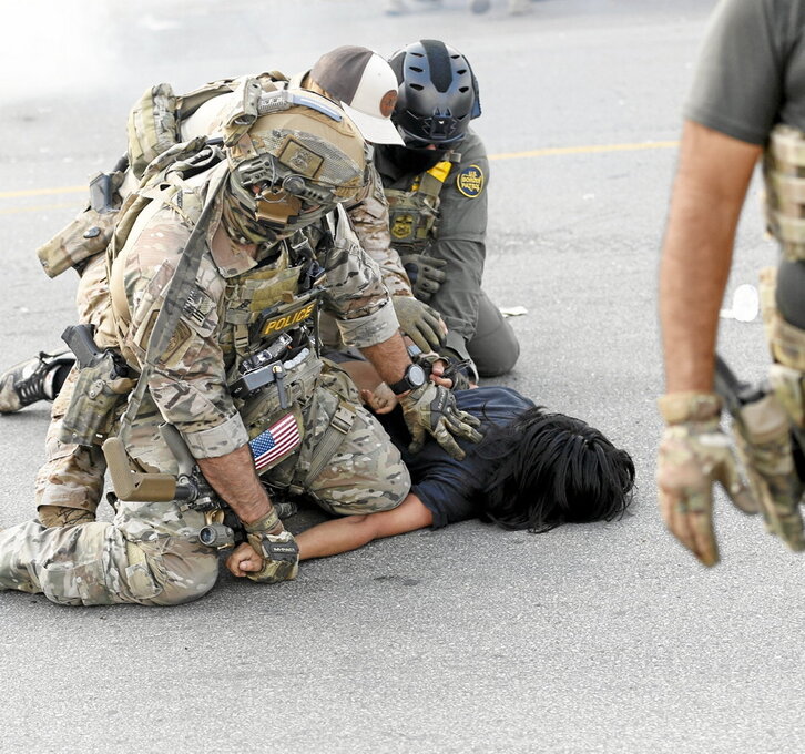 Un manifestante es detenido en el barrio Brighton Park de Chicago.