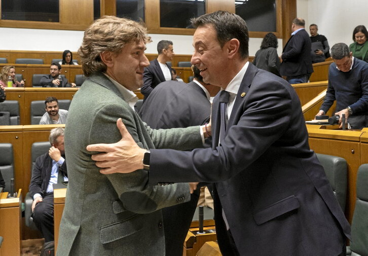 Eneko Andueza y Mikel Torres se saludan en el Parlamento. Al fondo, en su escaño, Bingen Zupiria.