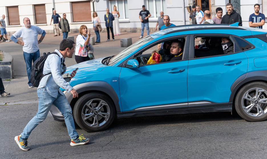 Ciudadanas y ciudadanos reaccionan al paso de un coche en el que se trasladaban participantes del acto fascista.