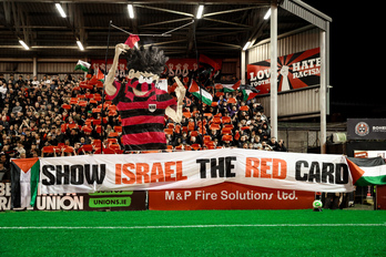La hinchada de los Bohs despliega una pancarta contra Israel.