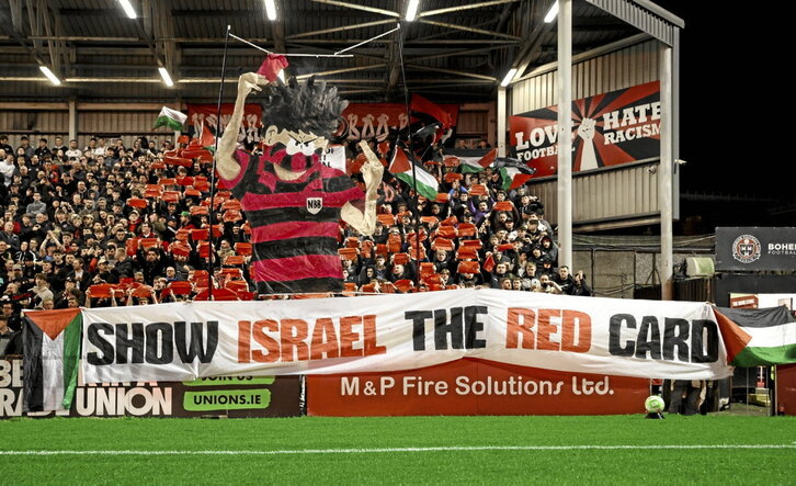 Abajo, la hinchada de los Bohs despliega una pancarta contra Israel.