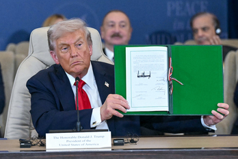 Donald Trump muestra el documento del acuerdo firmado.