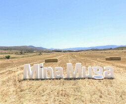 El logotipo de la mina Muga en un campo en el que pretendía instalarse.