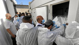 Trabajadores de la morgue descargan los cuerpos de palestinos que han estado bajo custodia israelí.