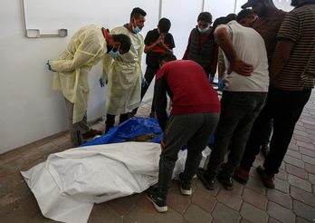  Trabajadores de la morgue del hosital Nasser observan uno de los cuerpo de palestinos entregado