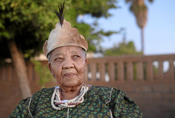 Katrina Esau, san herriaren nuu hizkuntzaren azken hiztun natiboa, larruzko koroarekin.