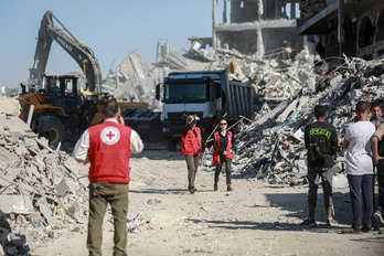   Miembros de Cruz Roja, con maquinaria de Egipto, buscan cuerpos de israelíes en la ciudad de Gaza bajo control israelí.