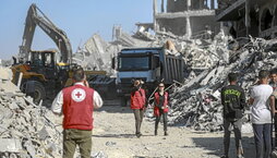 Miembros de Cruz Roja, con maquinaria de Egipto, buscan cuerpos de israelíes en la ciudad de Gaza bajo control israelí.