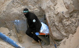 Un miliciano recupera en un túnel el cuerpo de un prisionero cuya entrega se suspendió por las violaciones del alto el fuego.