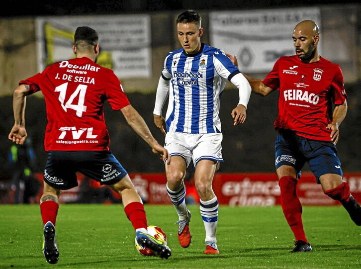 Turrientes conduce el balón entre dos jugadores del Negreira.