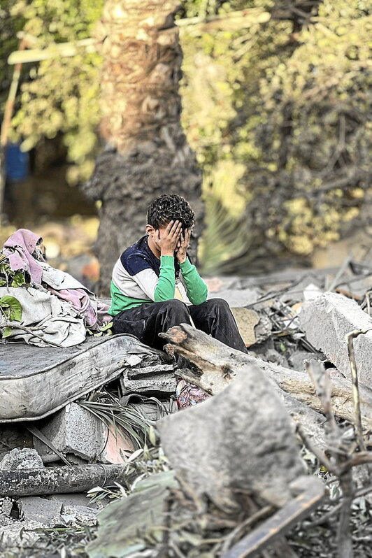 Un niño, sobre los restos de su casa en Nuseirat.