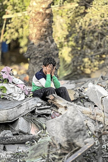 Un niño, sobre los restos de su casa en Nuseirat.