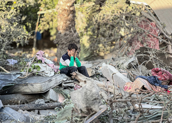 Un niño, sobre los restos de su casa en Nuseirat.