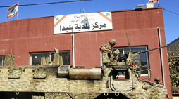 Un soldado libanés, sentado sobre un vehículo militar frente al Ayuntamiento de Blida.