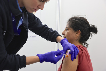 Una mujer recibe una dosis de la vacuna contra la gripe.
