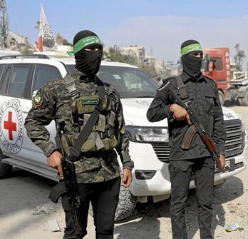 Miembros de Hamas y de la Cruz Roja buscan cuerpos de israelíes en Gaza.