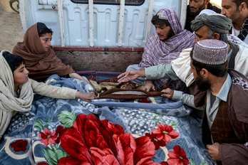Afganistango gizon talde bat, Kandaharreko Spin Boldak barrutiko herrixka batean, Pakistandik mugaz gaindiko tiroketaren ondorioz hildako biktimen gorpuen ondoan, azaroaren 7an.