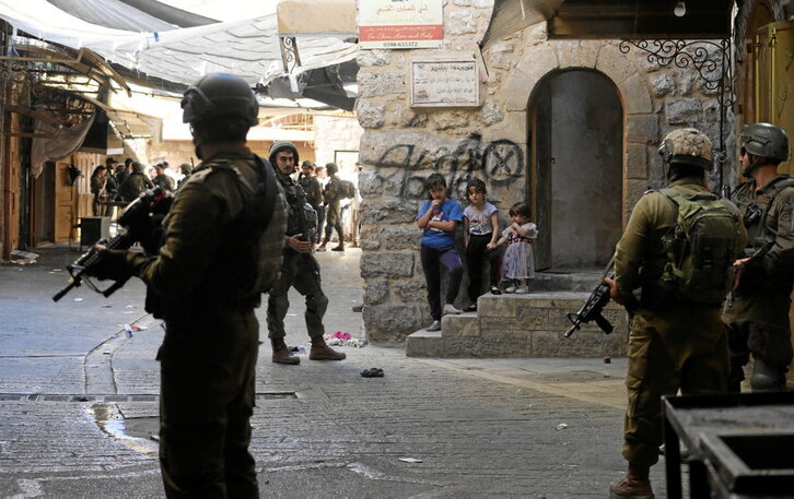 Varias niñas observan a soldados israelíes en la Ciudad Vieja de Hebrón.