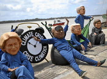 Protesta de Oxfam con Von der Leyen (UE), Ramaphosa (Sudáfrica), Trump (EEUU), Carney (Canadá) y Milei (Argentina) descansando mientras la crisis climática se agudiza.