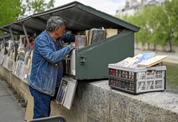 Un buquinista clasificando sus libros en París.