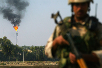 Un militar patrulla con la refinería de petróleo de Dora al fondo, en el sur de Bagdad, en 2008. 