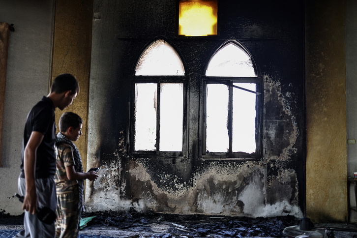 Dos niños fotografían los daños en la mezquita de Hajja Hamida, atacada por colonos.