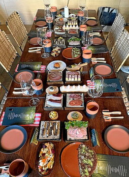 Aspectos de la mesa que se preparó para el almuerzo del evento Lurra, primero vacía y, a la izquierda, bien surtida.