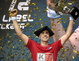 Peio Etxeberria, podiumean, txapelarekin eta besoan bere semea duela.