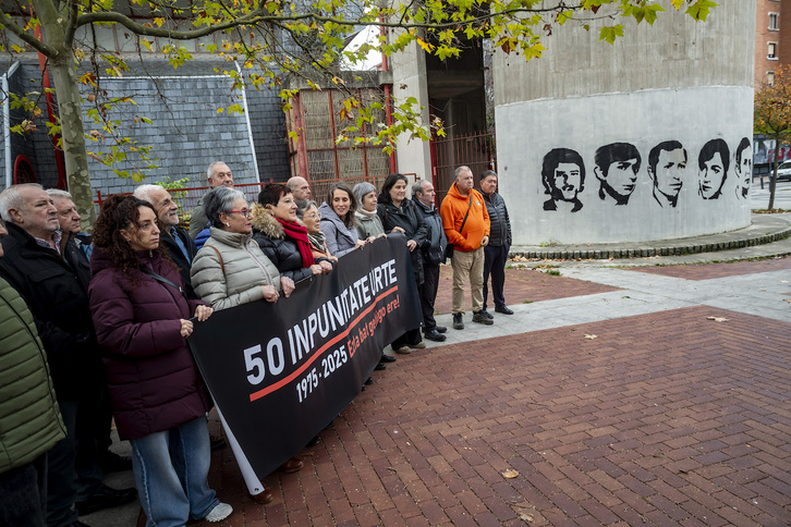 Integrantes de Martxoak 3 y SF 78 Gogoan junto a un mural con el rostro de los fallecidos el 3 de Marzo.