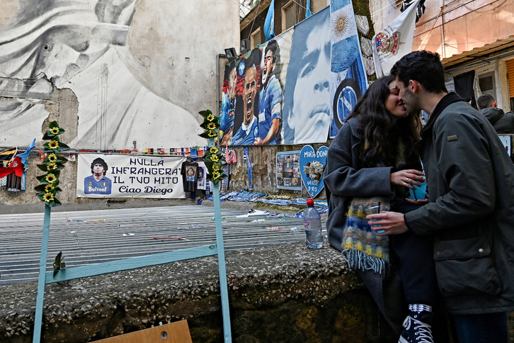 Una pareja se besa en la mítica Via Emanuele de Deo de Nápoles, lugar de recuerdo de Maradona.