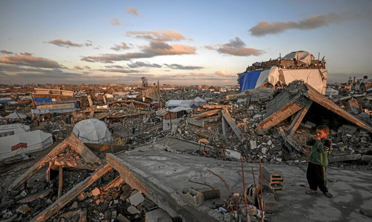Desplazatutako haur palestinar bat, hondakin bihurtutako Jabalia hiriari begira.