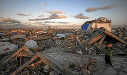 Desplazatutako haur palestinar bat, hondakin bihurtutako Jabalia hiriari begira.