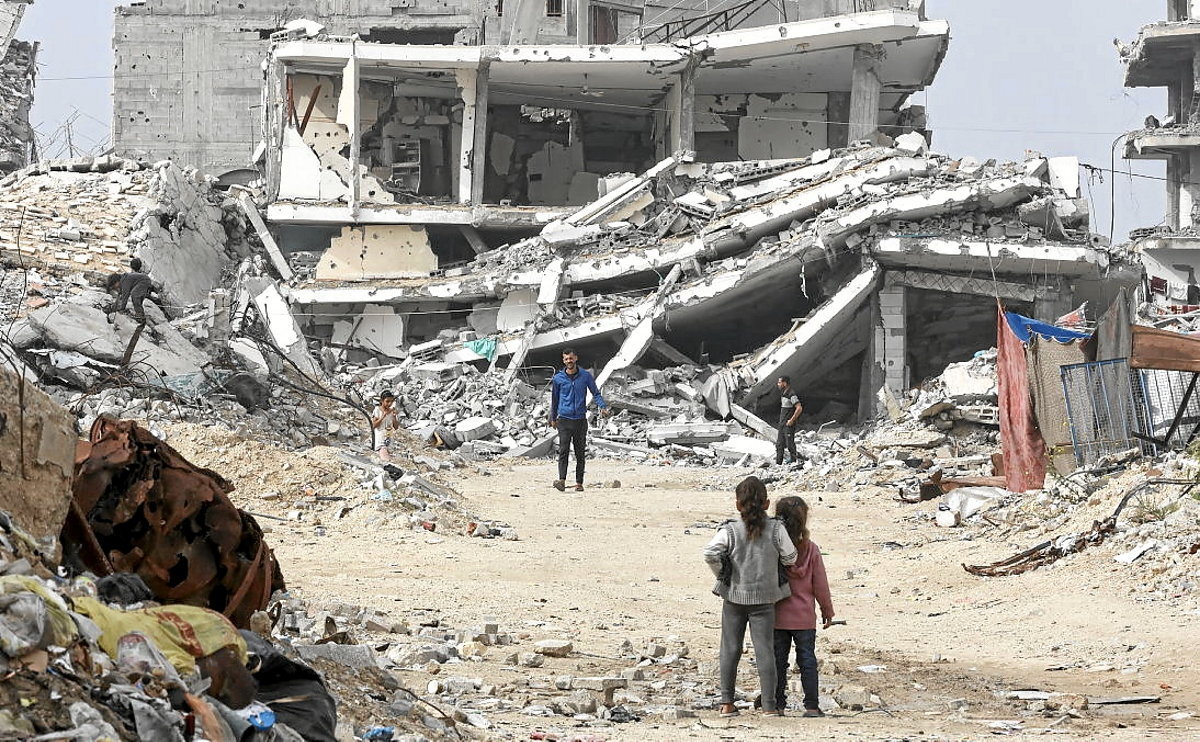 Palestinos entre las ruinas de Tel al-Hawa, en Ciudad de Gaza. (Omar AL QATAA / AFP)