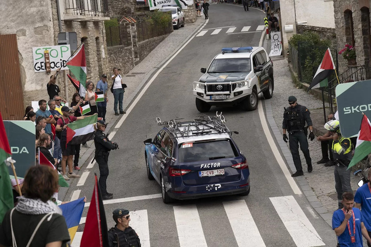 Un coche del equipo Israel Premier Teach pasa entre protestas propalestina.