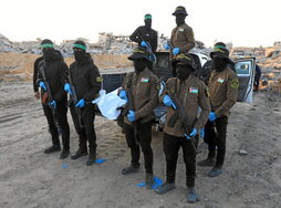 Milicianos de Hamas y la Yihad Islámica transportan el cuerpo de un prisionero en Beit Lahia.