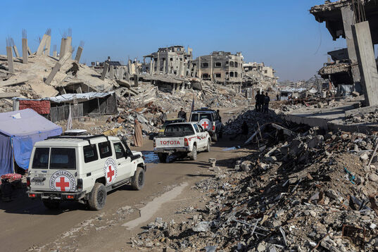 Un convoy médico de Cruz Roja avanza entre las ruinas de Gaza.