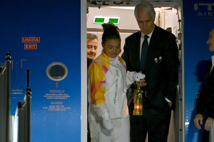 La tenista Jasmine Paolini y Giovanni Malagò, presidente de la Fundación Milán-Cortina 2026, bajan del avión el fuego olímpico.
