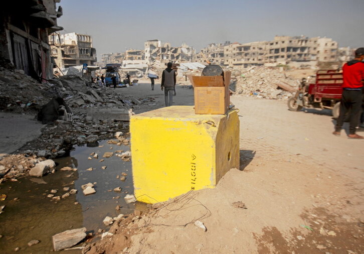 Uno de los bloques que delimita la «línea amarilla» en Bureij. Arriba, tiendas de desplazados entre las ruinas de Yabalia.