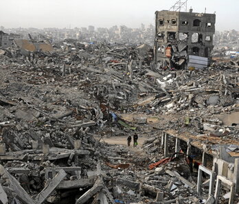 Palestinos caminan entre barrios destruidos en Yabalia.