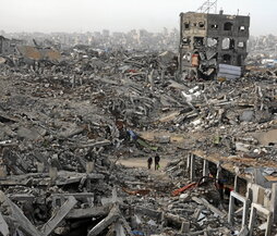 Palestinos caminan entre barrios destruidos en Yabalia.