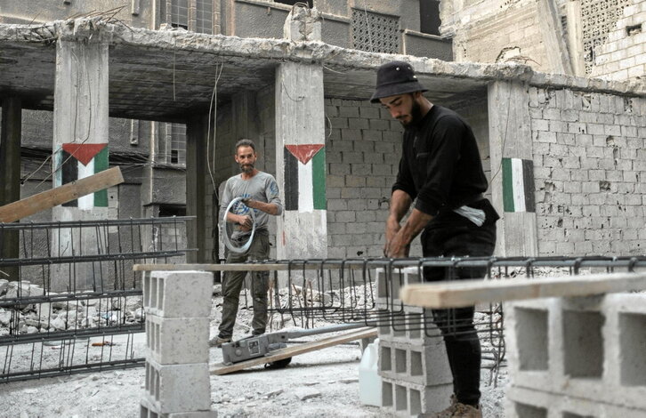 Palestinos trabajan en la reconstrucción de una vivienda en el campo de refugiados de Yarmuk, en Damasco.