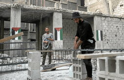 Palestinos trabajan en la reconstrucción de una vivienda en el campo de refugiados de Yarmuk, en Damasco.