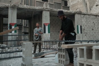 Palestinos trabajan en la reconstrucción de una vivienda en el campo de refugiados de Yarmuk, en Damasco.