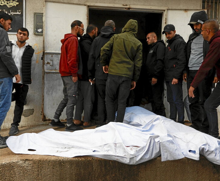 Palestinos junto a los cadáveres de las víctimas en el hospital Al-Shifa.