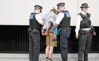 Un manifestante es detenido tras bloquear la carretera que conduce al puente Vauxhall en Londres.