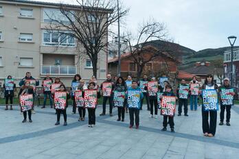 Vecinas y vecinos de Abanto portan carteles de la manifestación convocada para este viernes.