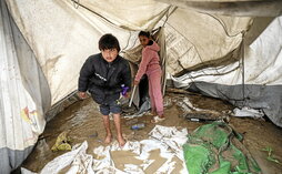 Niños palestinos en una tienda inundada en el campamento de Bureij.